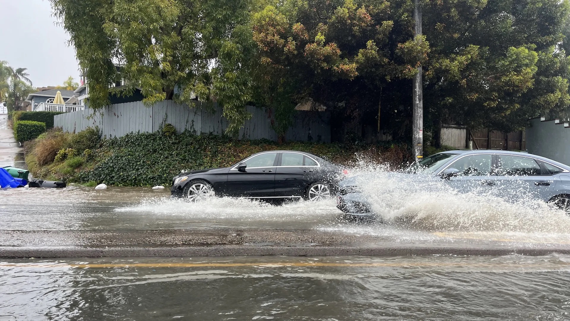 Cars drive through flooded streets in Point Loma.
