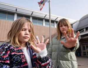 Irene Hayes, 7, left, and Pearl Hayes, 10, show their bandages from the lead screening March 15 at Bradley Technology and Trade High School in Milwaukee. Jovanny Hernandez / Milwaukee Journal Sentinel